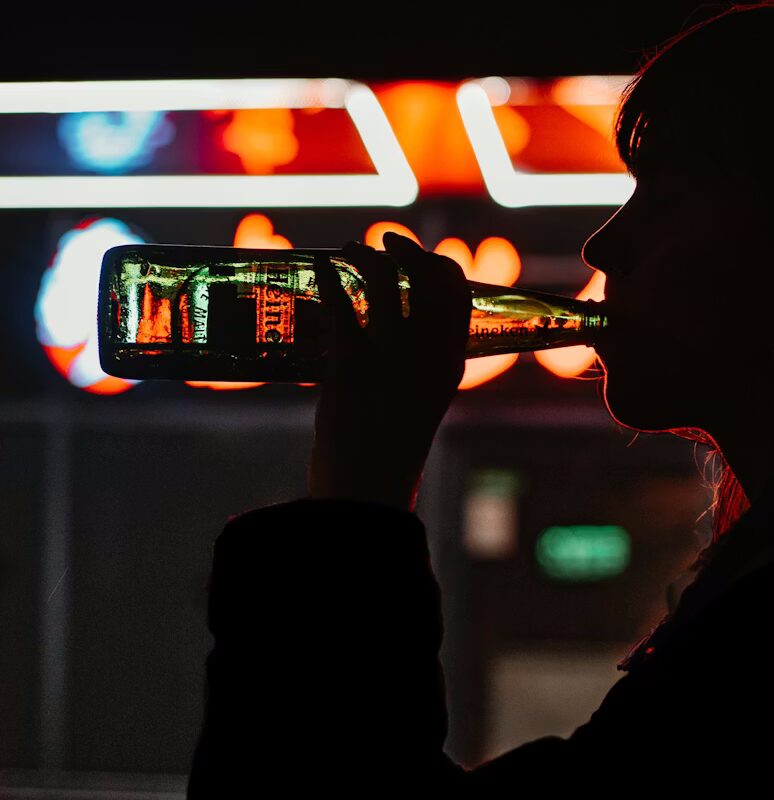 person drinking and illuminated by light